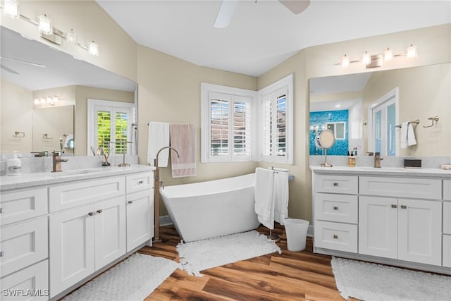 bathroom with ceiling fan, vanity, a bath, and hardwood / wood-style flooring