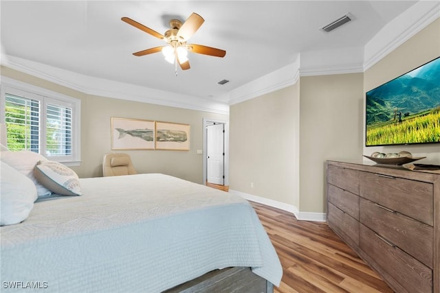 bedroom with ceiling fan, light wood-type flooring, and ornamental molding