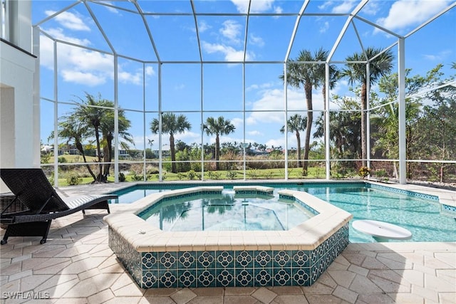 view of swimming pool featuring glass enclosure, an in ground hot tub, and a patio area