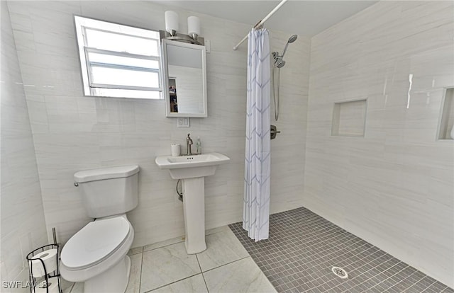 bathroom featuring a shower with curtain, toilet, tile walls, and sink