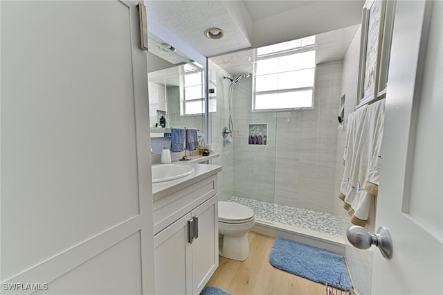 bathroom with toilet, vanity, an enclosed shower, and hardwood / wood-style flooring