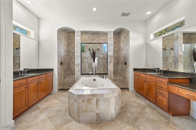 bathroom featuring shower with separate bathtub, vanity, and tile patterned floors