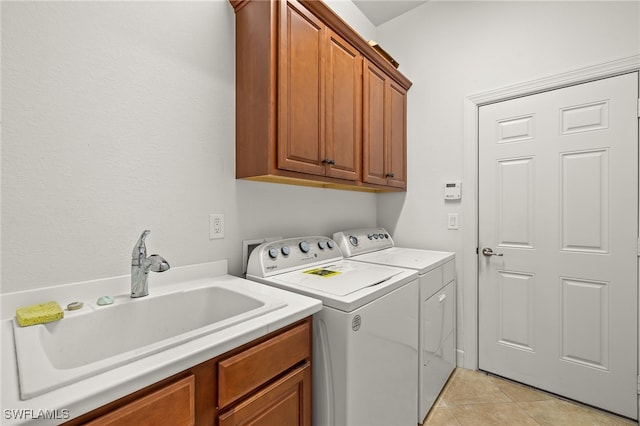 laundry area with cabinets, light tile patterned floors, sink, and washing machine and clothes dryer