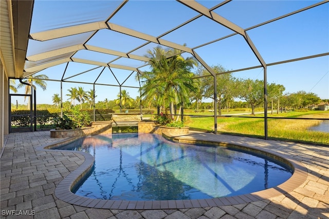 view of swimming pool featuring glass enclosure, a patio, and a hot tub