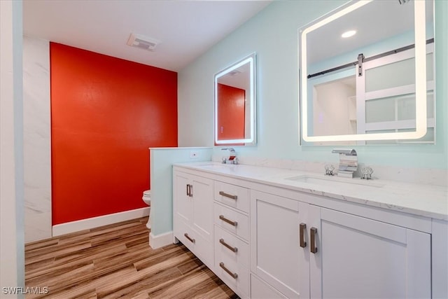 bathroom featuring hardwood / wood-style floors, vanity, and toilet