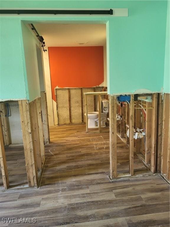 miscellaneous room featuring a barn door and wood-type flooring