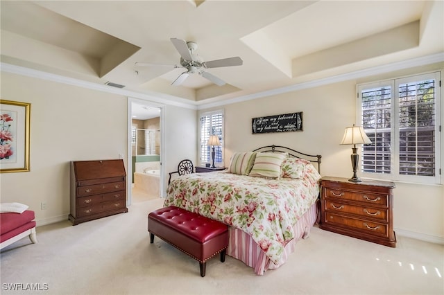 carpeted bedroom featuring a raised ceiling, ensuite bathroom, crown molding, and ceiling fan