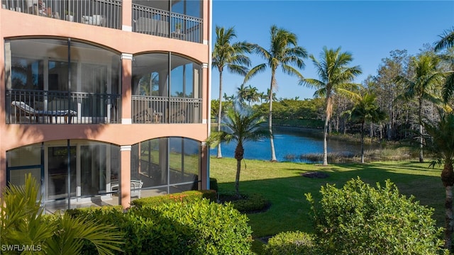 back of property featuring a water view and a yard