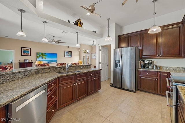 kitchen featuring dark stone counters, stainless steel appliances, ceiling fan, sink, and decorative light fixtures