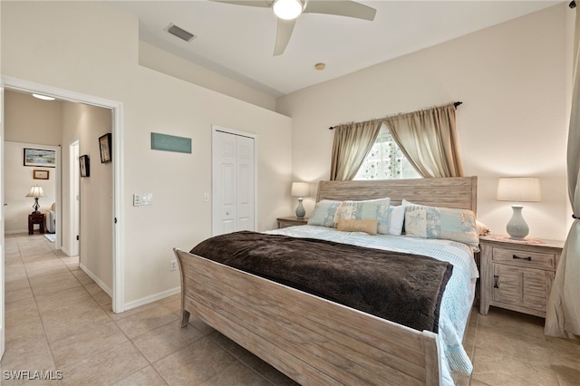 tiled bedroom with ceiling fan and a closet