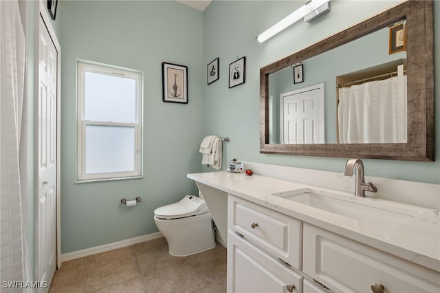 bathroom with tile patterned flooring, vanity, and toilet