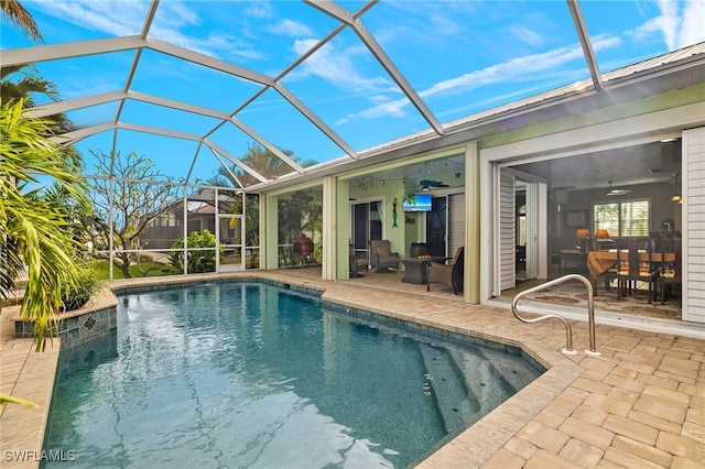 view of swimming pool featuring a patio area, ceiling fan, and glass enclosure