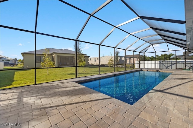 view of pool with a lawn, glass enclosure, and a patio