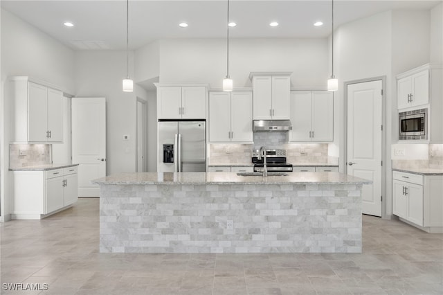 kitchen with appliances with stainless steel finishes, a center island with sink, pendant lighting, and sink