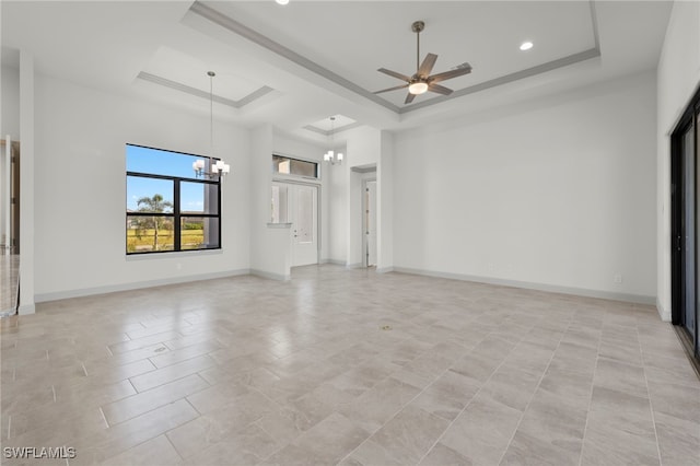 unfurnished living room featuring light tile patterned floors, ceiling fan with notable chandelier, and a raised ceiling