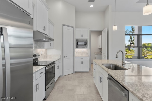 kitchen featuring light stone countertops, sink, white cabinets, and stainless steel appliances