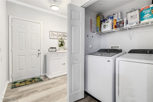 clothes washing area featuring washer and dryer and light hardwood / wood-style floors