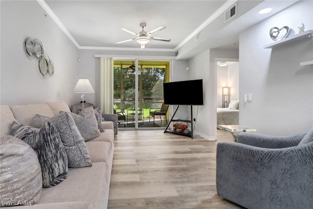 living room with ceiling fan, ornamental molding, and light wood-type flooring