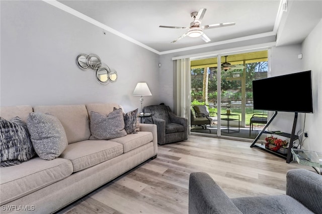 living room featuring light hardwood / wood-style flooring, ceiling fan, and ornamental molding