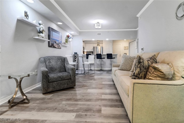 living room with wood-type flooring and crown molding