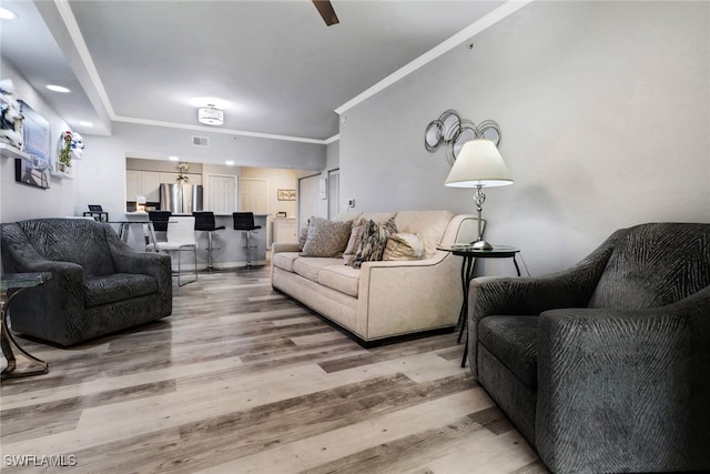 living room with light hardwood / wood-style flooring and ornamental molding