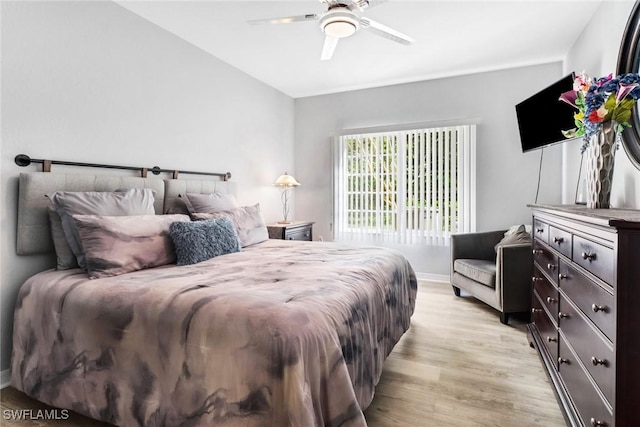 bedroom with ceiling fan, lofted ceiling, and light wood-type flooring