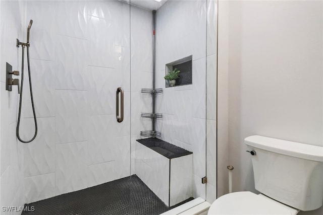 bathroom featuring toilet and a shower with shower door