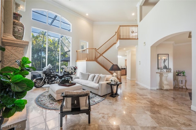 living room featuring a towering ceiling and crown molding