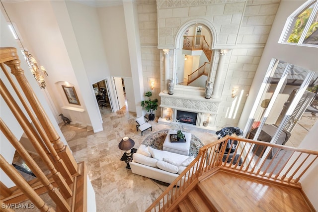 living room with a towering ceiling, a chandelier, and hardwood / wood-style flooring