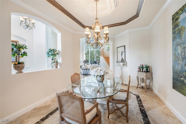 dining area with a tray ceiling, crown molding, and a notable chandelier