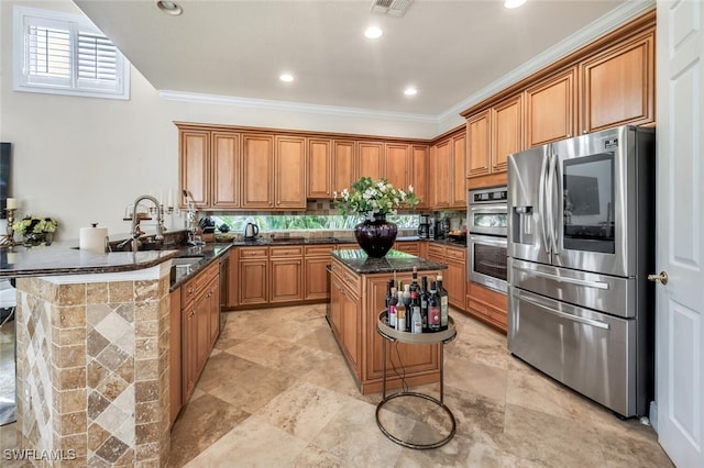 kitchen with sink, dark stone countertops, ornamental molding, appliances with stainless steel finishes, and kitchen peninsula