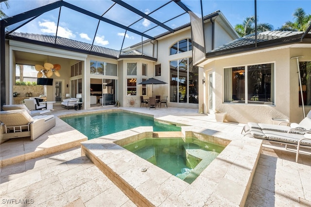 back of house with a swimming pool with hot tub, a patio, and glass enclosure