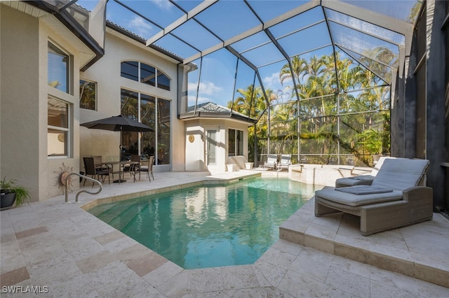 view of pool with a patio and glass enclosure