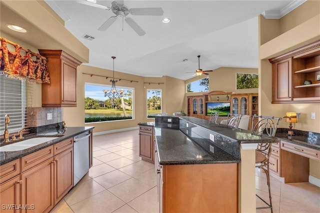 kitchen with a kitchen breakfast bar, stainless steel dishwasher, dark stone counters, vaulted ceiling, and light tile patterned floors