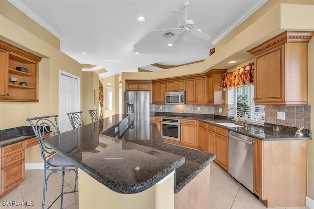 kitchen featuring a kitchen bar, light tile patterned flooring, a kitchen island, and stainless steel appliances