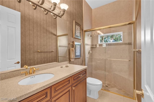 bathroom featuring tile patterned floors, vanity, toilet, and a shower with door