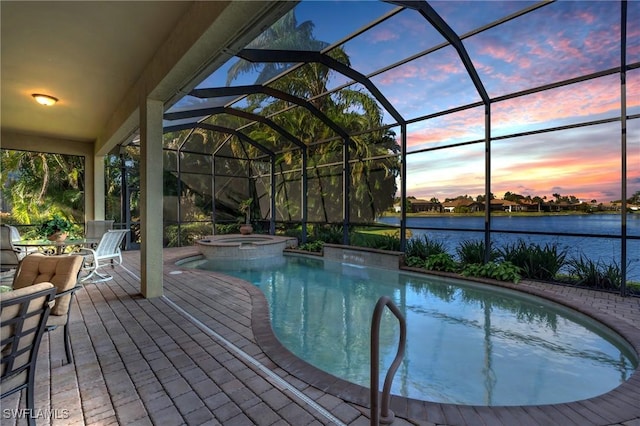 pool at dusk featuring an in ground hot tub, a water view, and a lanai