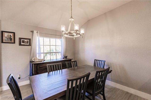 dining space featuring wood-type flooring, an inviting chandelier, and lofted ceiling