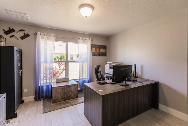 office area with a textured ceiling and light hardwood / wood-style flooring