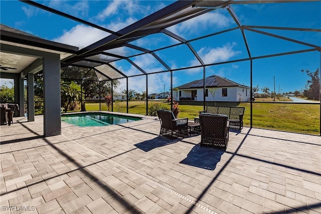 view of swimming pool featuring ceiling fan, a lanai, a patio area, and a lawn