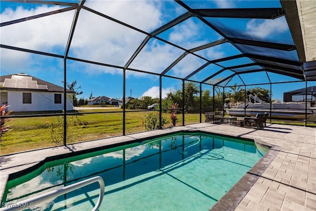 view of pool with a lanai, a patio area, and a lawn