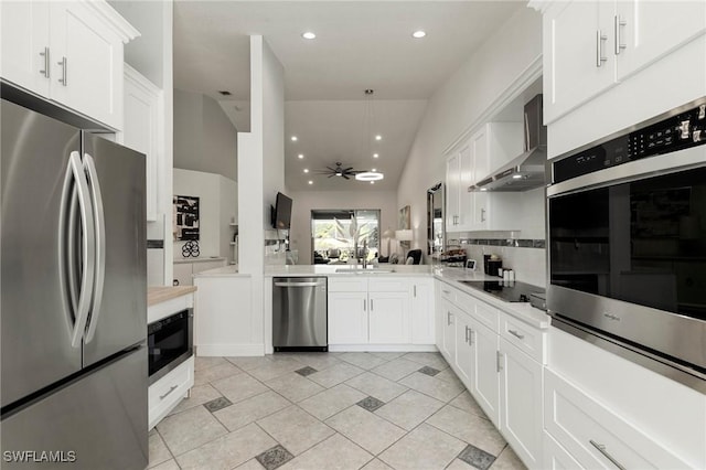 kitchen featuring white cabinets, ceiling fan, wall chimney exhaust hood, and black appliances