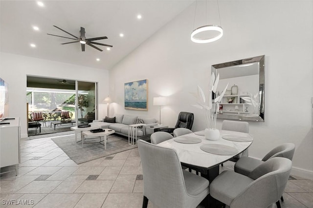 dining space with ceiling fan, light tile patterned floors, and high vaulted ceiling