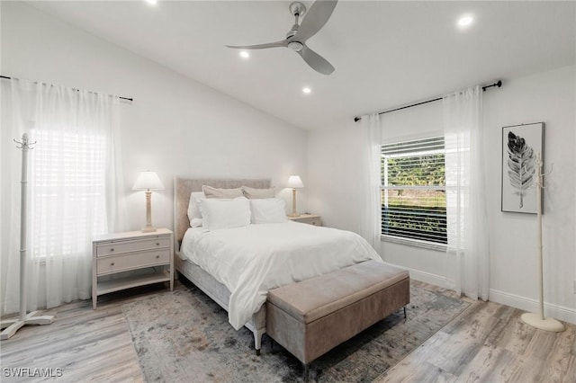 bedroom with ceiling fan, light wood-type flooring, and lofted ceiling