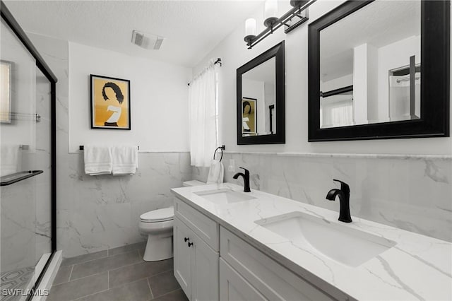 1700 Royal Cir Unit 601, Naples, FL 34112 - full bathroom featuring tile walls, a marble finish shower, double vanity, a textured ceiling, and a wainscoted wall
