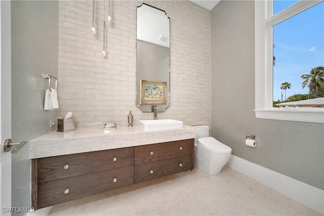 bathroom with visible vents, toilet, vanity, baseboards, and tile patterned floors