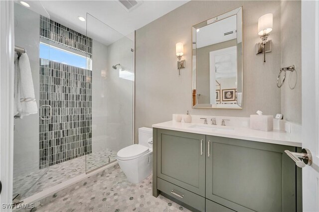 bathroom featuring visible vents, vanity, toilet, and a walk in shower