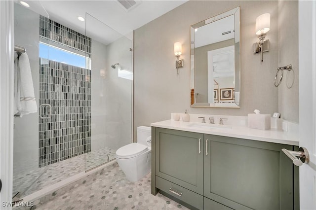 full bathroom with vanity, toilet, visible vents, and tiled shower