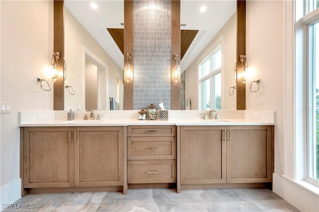 full bathroom featuring marble finish floor, a sink, and double vanity