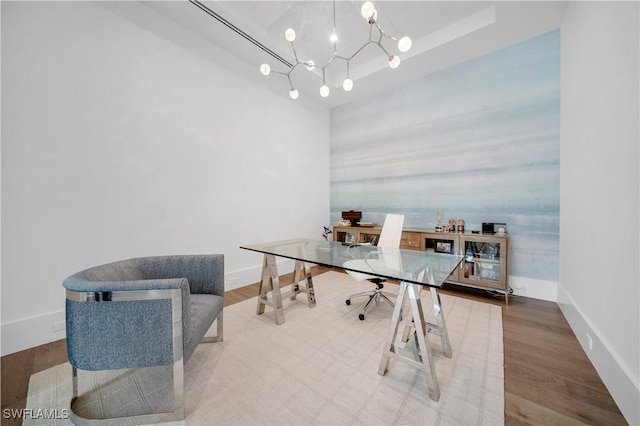 home office with a notable chandelier, baseboards, and wood finished floors